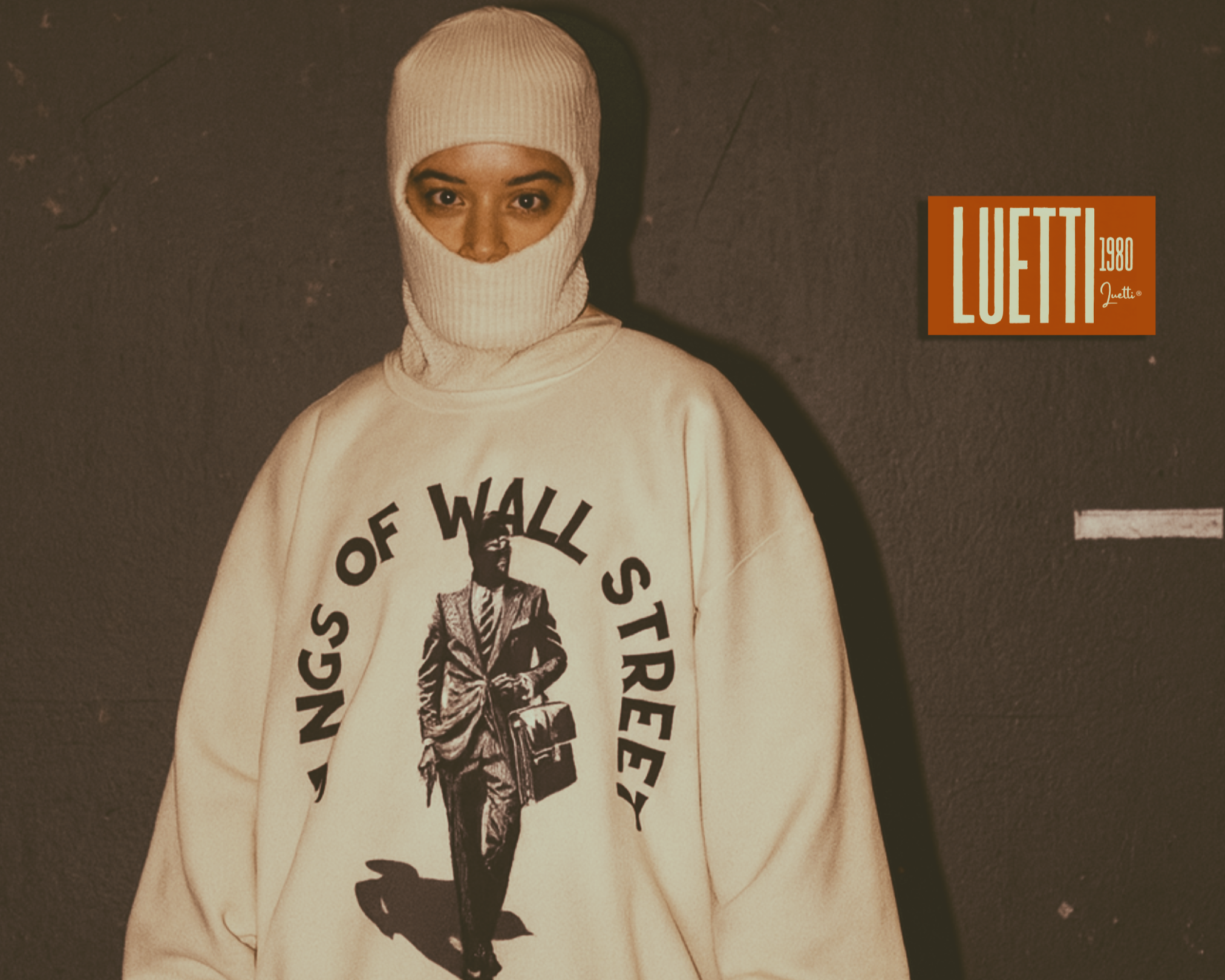 Person wearing a white hoodie with 'Wall Street' graphic and text, standing against a dark background.